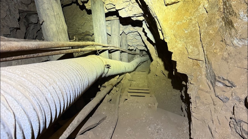 A timbered tunnel deep inside the War Eagle mine, lit by a headlamp